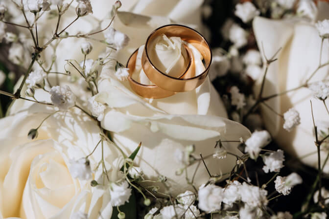 golden-wedding-rings-white-rose-from-wedding-bouquet-1-1.jpg